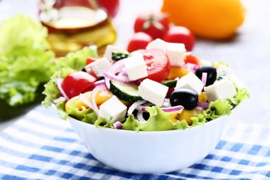 Ahşap masa mavi peçeteye kase sebze salatası