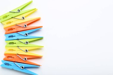 Beyaz arka plan üzerinde renkli plastik clothespins dönüştürün