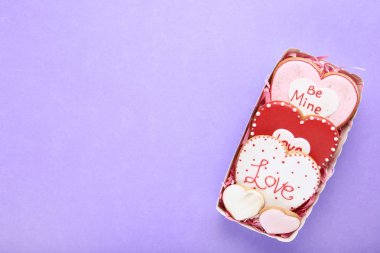 Sevgililer günü kalp kurabiye kutusunda mor zemin üzerine şeklinde