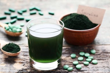 Spirulina içki ve tablet toz kase gri ahşap tablo