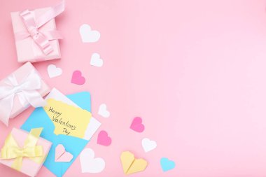 Yazıt Sevgililer günü hediye kutuları ve pembe bir arka plan üzerinde zarf ile