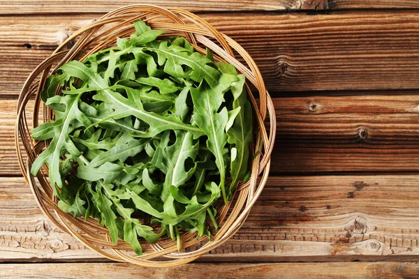 Grüne Rucolablätter Korb Auf Braunem Holztisch — Stockfoto