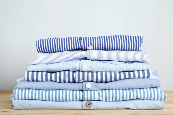 Stack of folded shirts on grey background