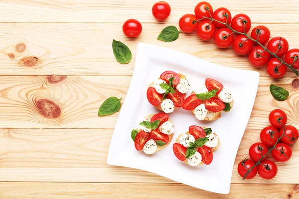 Bruschettas Com Mussarela Tomates Folhas Manjericão Mesa Madeira Marrom — Fotografia de Stock