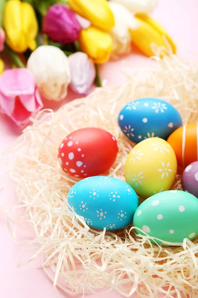 Yuvaya Pembe Bir Arka Plan Üzerinde Renkli Paskalya Yumurtaları — Stok fotoğraf