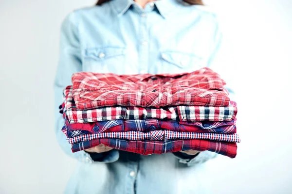 Female hands holding folded shirts
