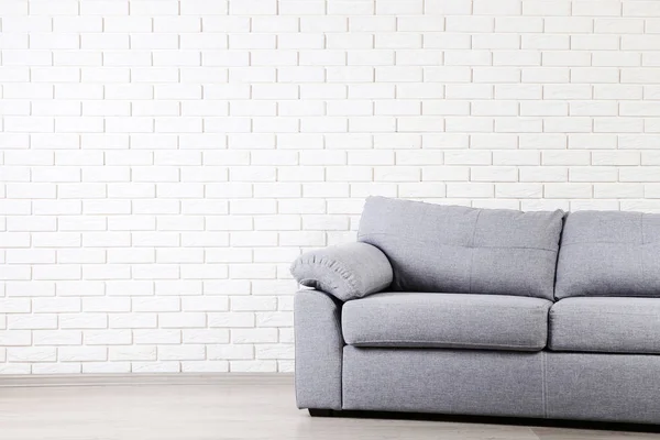 Modernes Graues Sofa Auf Backsteinwand Hintergrund — Stockfoto