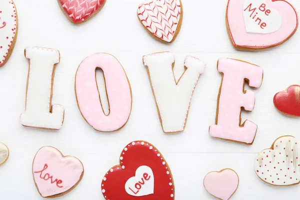 Valentine day cookies and word Love on white wooden table
