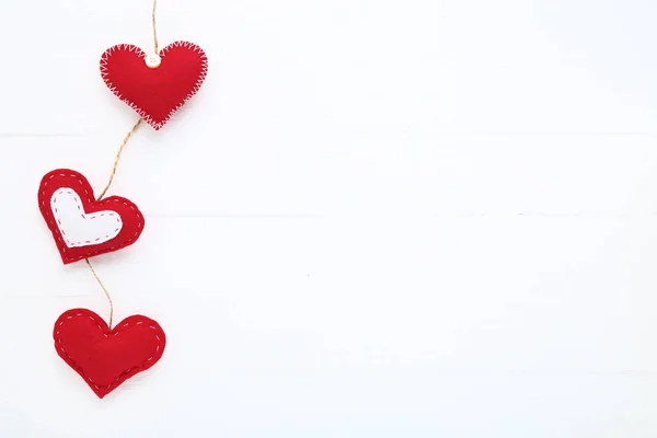 白色木桌上的红色织品心脏 — 图库照片