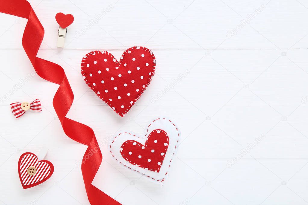 Fabric hearts with clothespins and ribbon on white wooden table
