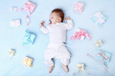 Yatakta yatıyordu hediye kutuları ile şirin bebek