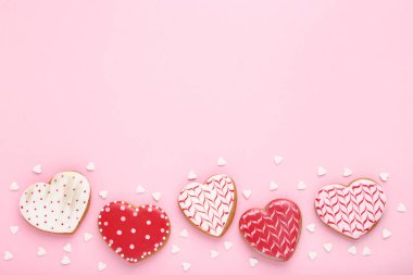 Sevgililer günü kurabiyeleri kalp ile sprinkles pembe bir arka plan üzerinde şeklinde