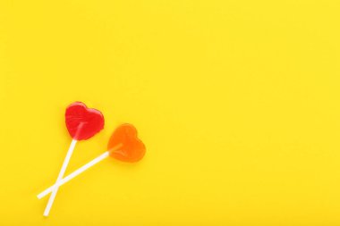 Lolipop sarı arka plan üzerinde kalp şeklinde
