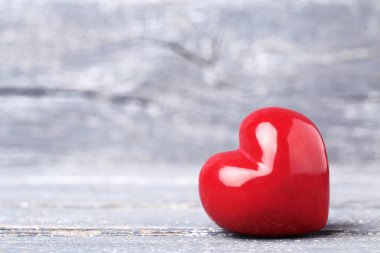 Gri ahşap masa üzerinde kırmızı kalp