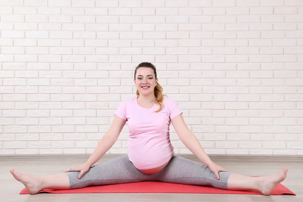 Unga Gravid Kvinna Gör Övningar Tegel Vägg Bakgrund — Stockfoto