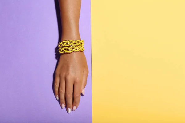 Mano Femenina Con Pulseras Sobre Fondo Colorido —  Fotos de Stock