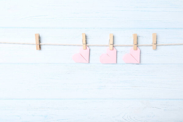 Paper hearts hanging on rope with clothespins