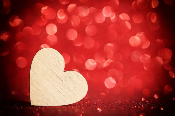 棕色木心脏在红色 Bokeh 灯背景 — 图库照片