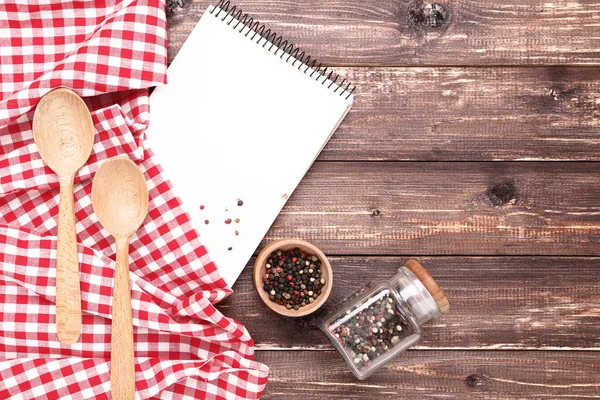 空白记事本与红色餐巾 勺子和胡椒香料在木制背景 — 图库照片