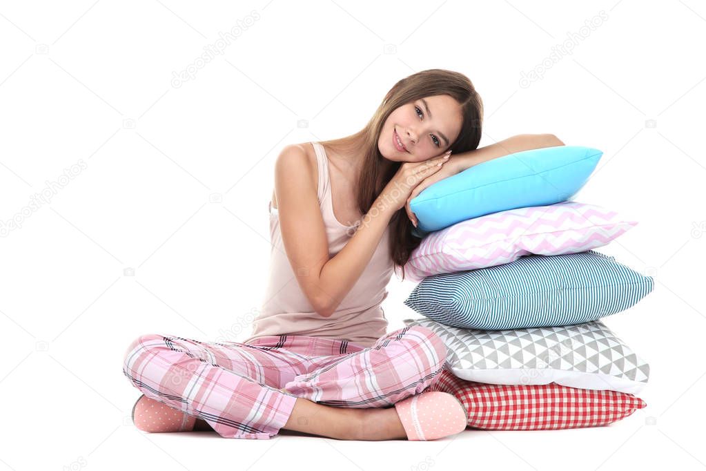Young girl with colorful pillows sitting on white background