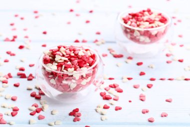 Sprinkles cam kase ahşap masa üzerinde kalp şeklinde