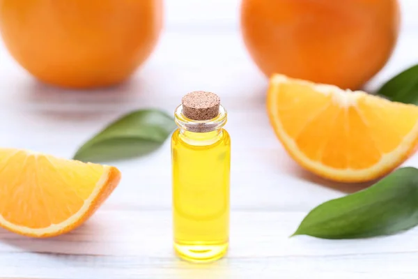 Aceite Naranja Botella Con Hojas Verdes Sobre Mesa Madera —  Fotos de Stock