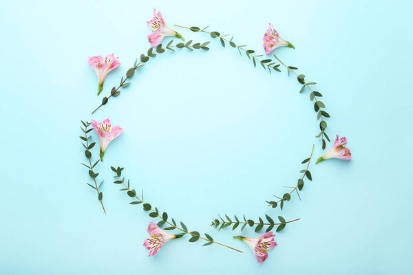 Alstroemeria flowers and stems with green leaves on blue background