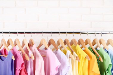 Tuğla duvar arka plan üzerinde asılı moda giysiler