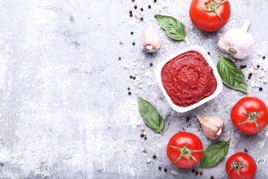 Kase Fesleğenli ketçap yapraklar ve gri ahşap masaya sarımsak