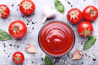 Kase Fesleğenli ketçap yapraklar ve gri ahşap masaya sarımsak