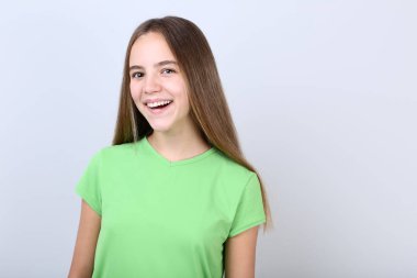 Gri arka plan üzerinde tişört giyen genç kız