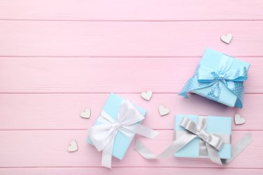 Hediye kutuları pembe ahşap masa üzerinde küçük beyaz yürekleri