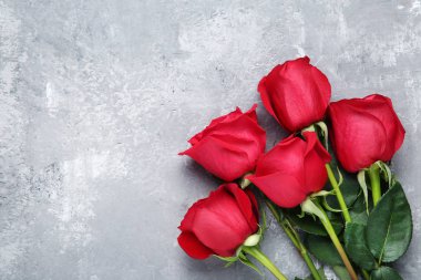 Gri ahşap masa üzerinde kırmızı gül buketi