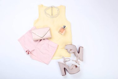 Beyaz arka plan üzerinde parfüm şişesi ile şık kadın giyim