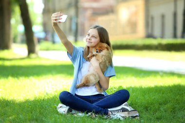 Pomeranian köpek selfie parkta yapma ile genç kız