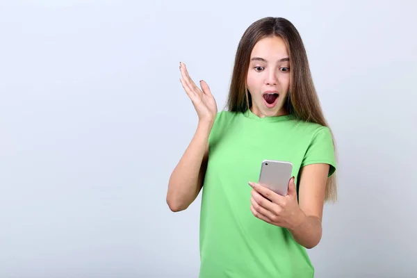 Menina Surpresa Com Smartphone Fundo Cinza — Fotografia de Stock