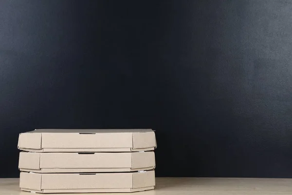 Stack of pizza boxes on blackboard background