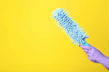 Kadın el Temizleme silme sarı arka plan üzerinde tutarak