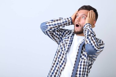 Gömlek gri arka plan üzerinde şaşırmış genç adam