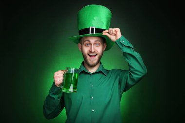 Aziz Patrick günü. Bardak bira ile yeşil şapka giyen genç adam