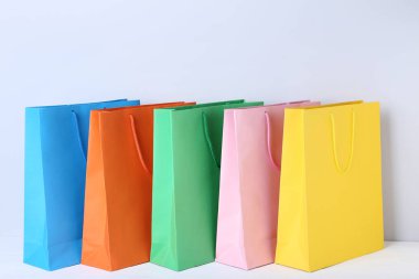 Gri arka plan üzerinde renkli kağıt poşetler