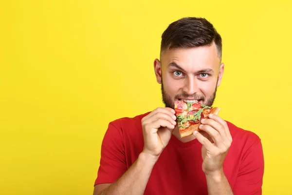 Ung Man Äta Pizza Gul Bakgrund — Stockfoto