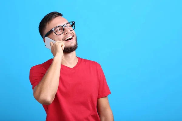 Νεαρός Άνδρας Μιλάμε Για Ένα Κινητό Τηλέφωνο Μπλε Φόντο — Φωτογραφία Αρχείου