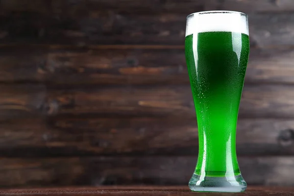 St. Patrick\'s Day. Glass of green beer on wooden background