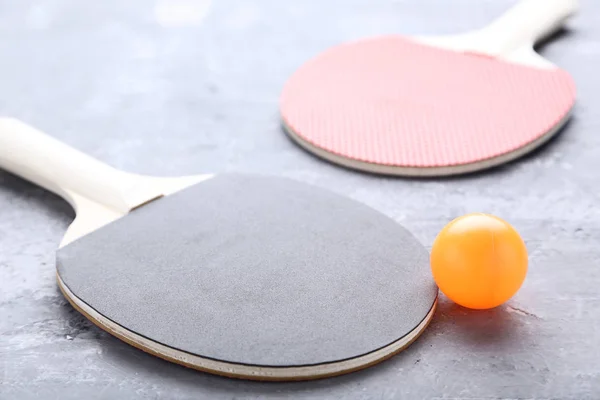 灰色の木製のテーブルの上にボールを卓球ラケット — ストック写真