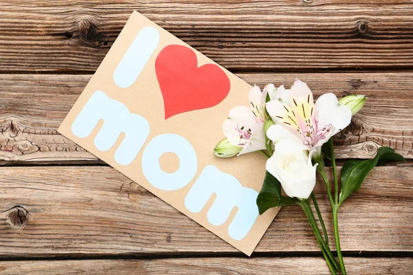 グリーティング本文カード愛ママと花茶色の木製のテーブルの上 — ストック写真