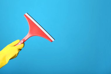 Mavi arka plan üzerinde windows için Temizleme Aracı tutan el