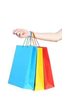 Beyaz arka plan üzerinde renkli alışveriş torbaları tutmak el