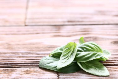 Kahverengi ahşap masa üzerinde yeşil fesleğen yaprakları