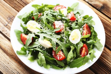 Roka Salatası yapraklar, domates ve yumurta üzerinde kahverengi ahşap tabl